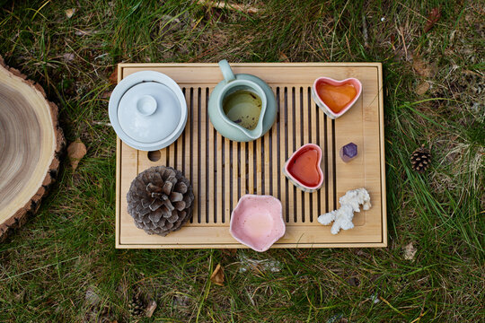 Chinese tea ceremony with gaiwan on wooden tray outdoors