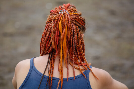 Back view of person with vibrant orange dreadlocks