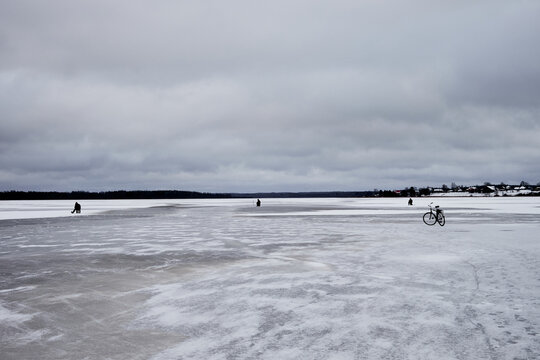 Ice fishing and bicycle on a frozen lake under clouds