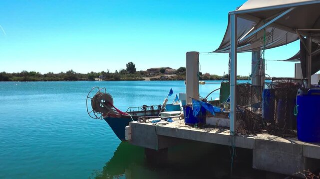 Fishing boat docked at quiet water on river Orb. Valras, France