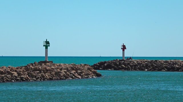 Two markers stand near a jetty by the ocean. Valras, France .