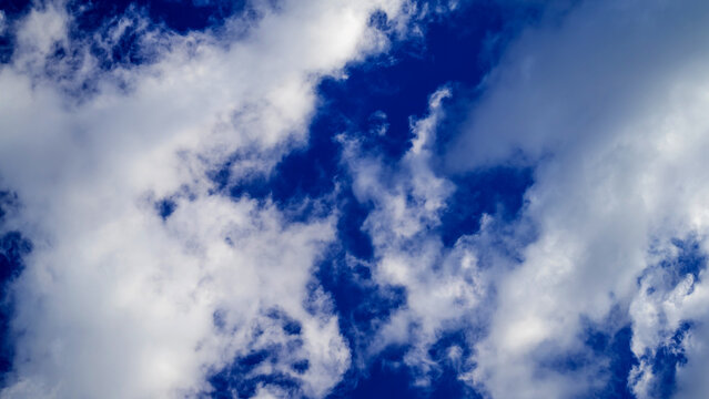 soft scattered wispy clouds evenly covering a vibrant blue sky