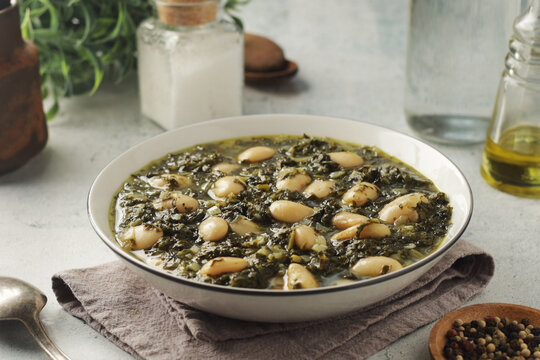 A bowl with traditional Tuscan kale salad and white beans soup Cavolo nero e fagioli
