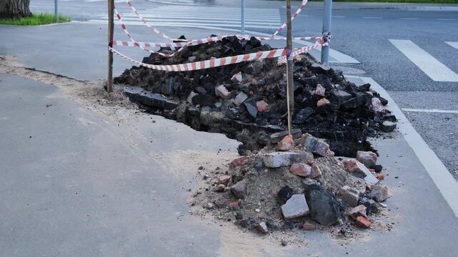 Roadwork creating hazardous conditions on sidewalk with rubble and caution tape