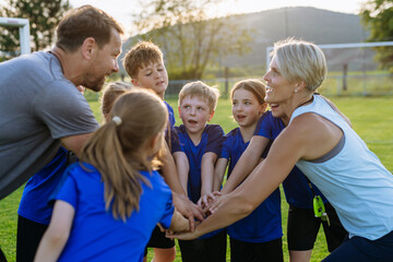 Fototapeta premium Young football players and coaches building team spirit before match.