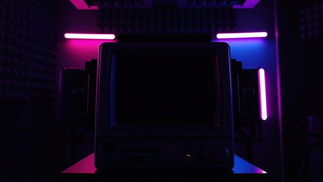 Retro computer setup. Dark room illuminated by vibrant pink, purple neon lights. Minimalist aesthetic, futuristic vibe.