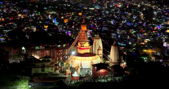 Kathmandu, Nepal, Aerial shot of the golden eyes and spire of Swayambhunath Monkey Temple glowing brightly, surrounded by festive decorations and valley city lights on a Tihar night