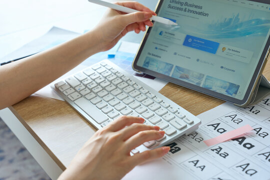 Woman's Hands Designing Website on Tablet with Stylus