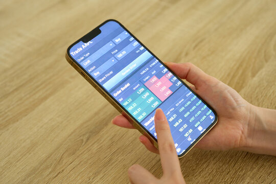 Woman's Hands Checking Stock Prices on Smartphone