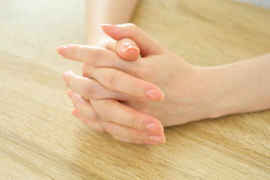 Young Woman With Clasped Hands Deep in Thought
