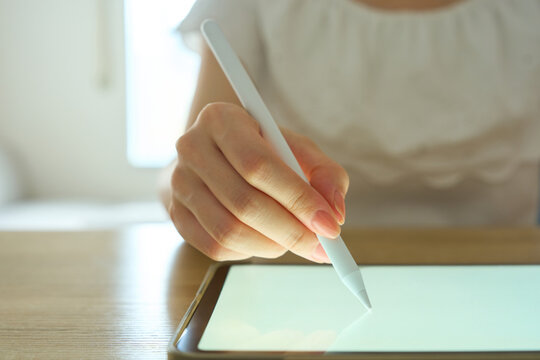 Young Womans Hand Writing on Digital Tablet with Stylus Pen