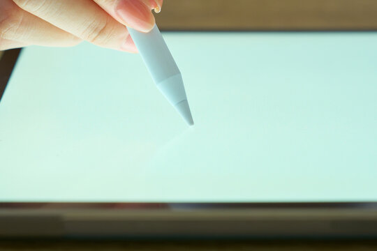 Young Womans Hand Writing on Digital Tablet with Stylus Pen