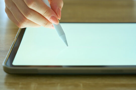 Young Womans Hand Writing on Digital Tablet with Stylus Pen