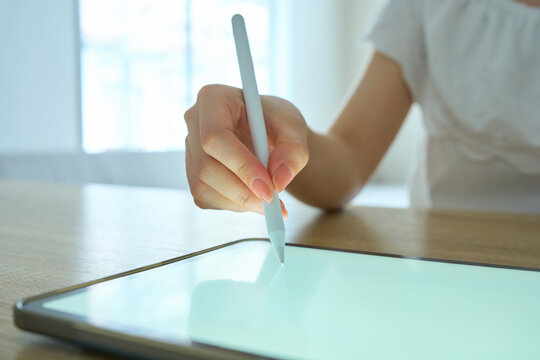 Young Womans Hand Writing on Digital Tablet with Stylus Pen