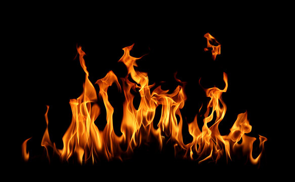 Realistic orange flames burning against a black background, creating a dramatic fire effect with glowing heat bright energy dynamic movement, isolated space and powerful visual texture for design use.