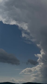 Pan Across Blue Sky and Dark Storm Clouds Above Distant Hills