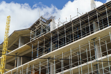 High-rise building under construction with scaffolding © IbragimovN