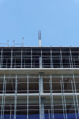High-rise building under construction against blue sky © IbragimovN