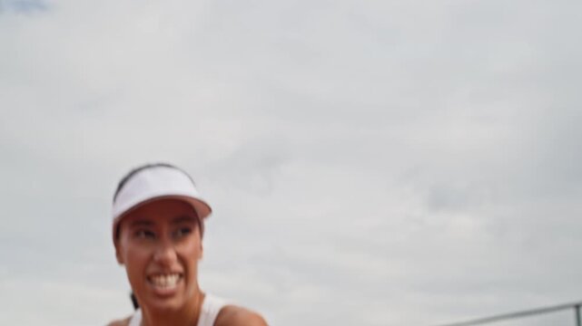 Young adult Biracial woman practicing backhand strikes with tennis racket on outdoor court. Dynamic athletic footage suitable for sportswear commercials, fitness campaigns, and training content