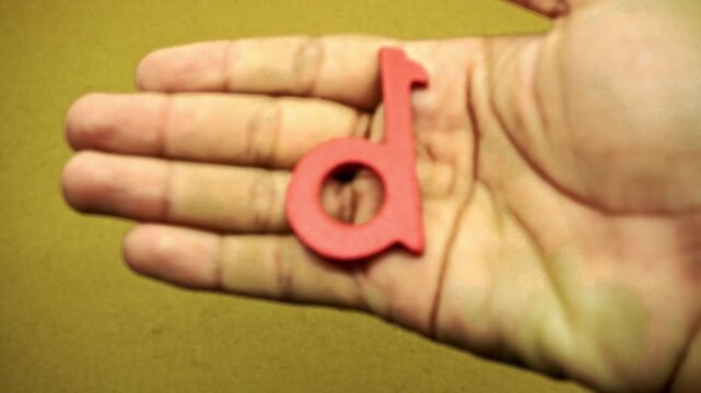 Colorful wooden letters arranged as ABCD placed on a textured surface and held in an open human hand for education and learning
