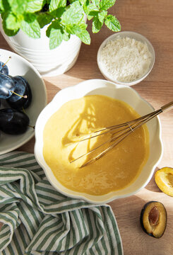 Baking plum cake ingredients with batter and flour