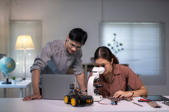Asian students collaborating on robotics engineering project