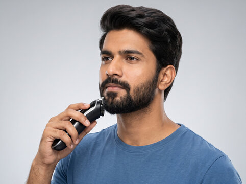 Handsome Indian Man Trimming Beard with Electric Grooming Trimmer