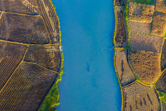 Aerial view of a winding river and harvested crop fields in the countryside of Quang Ngai, Vietnam