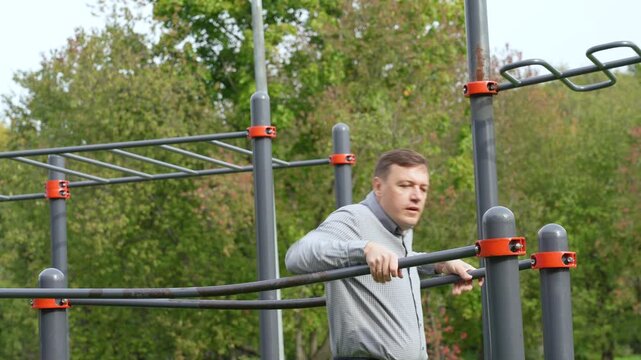 Man performing dips exercise on outdoor calisthenics equipment in park