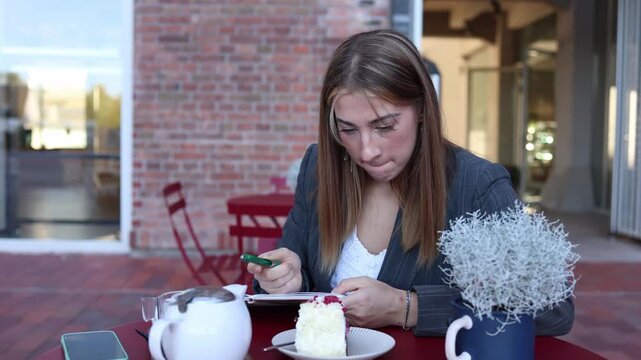 Food critic reviews her notes after tasting dessert at an outdoor cafe comparing observations before completing a professional evaluation of the dining service