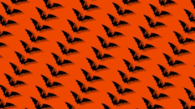 Animated seamless pattern of black bats flapping wings on bright orange background for halloween.