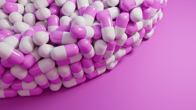 Pile of pink and white capsule pills on pink background