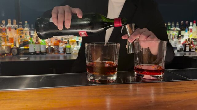 Professional Bartender Pouring Liquor into Jigger for Cocktail Preparation
