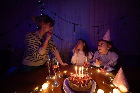 Celebration of joy with cake, candles, and laughter during a cozy indoor party at night with friends and family share sweet moments and festive vibes