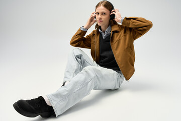 Stylish young man embraces fashion in a creative studio space while wearing headphones © Bliss