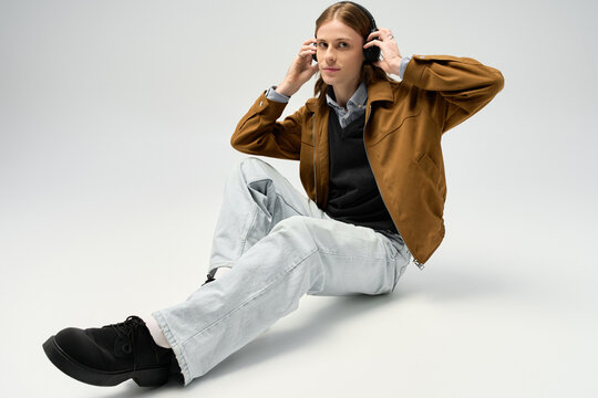 Stylish young man embraces fashion in a creative studio space while wearing headphones