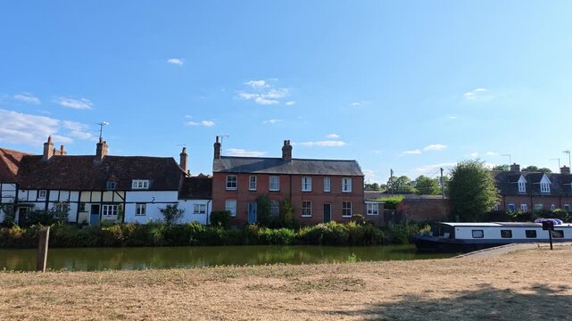 Hungerford Berkshire England UK. 28.08.2026. Video.  Narrowboat sailing  past scenic cottages on the Kennet and Avon Canal Hungerford  during the summer holiday season.