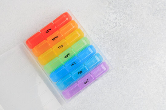 Weekly pill organizer with colored compartments for each day