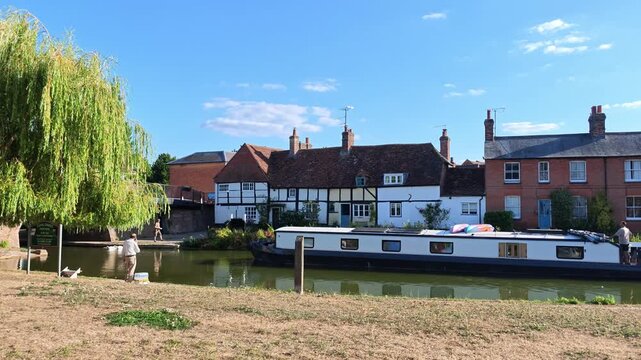 Hungerford Berkshire England UK. 28.08.2026. Video.  Narrowboat sailing  past scenic cottages on the Kennet and Avon Canal Hungerford  during the summer holiday season.