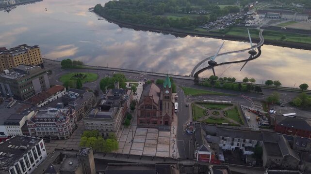 Aerial view of the Peace Bridge and the historic Guildhall along the River Foyle in Derry, United Kingdom.