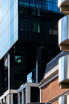 Glass architecture rises above historic brick facades in the City of London where office buildings and balconies shape the urban streetscape