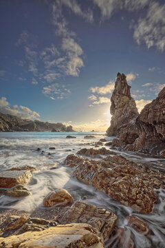 Backlit image at sunset of the sea stack at the east end of Playa del Silencio (Silence Beach), under an almost blue sky. Cudillero-Asturias-Spain-053