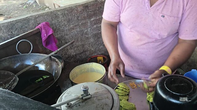 Indian Street Food Vendor Shaping Masala Potato Balls for Vada Pav Preparation Beside Deep Frying Wok and Gram Flour Batter Pot at Open Outdoor Food Stall Counter