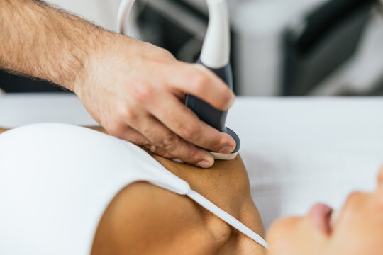 Physiotherapist using ultrasound on patient shoulder