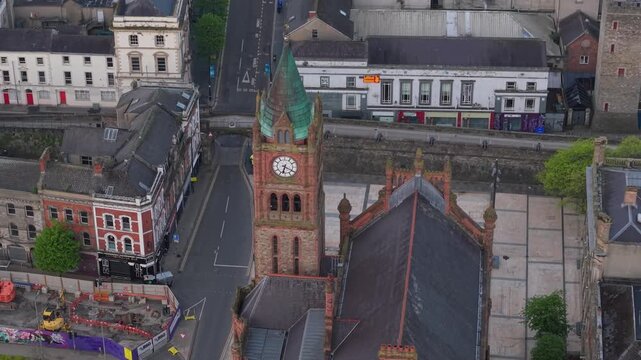 Aerial view of the historic Guildhall clock tower and surrounding urban streets in Derry, United Kingdom.