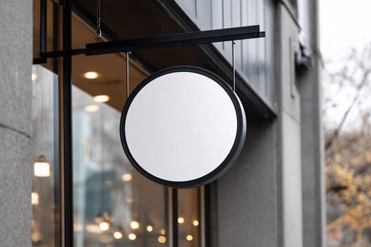 Modern round blank store sign hanging outside shop