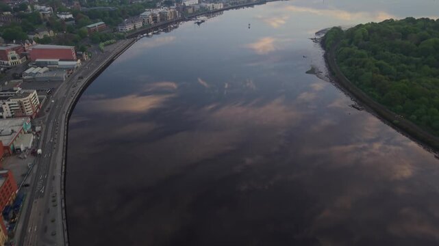 Aerial view of the River Foyle flowing past urban buildings and roads in Derry, Northern Ireland.