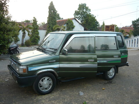 Classic metallic green Toyota Kijang Grand Extra retro mpv parked outside daytime. Iconic vintage 90s Indonesian family automobile side front view, well maintained classic automotive design concept.