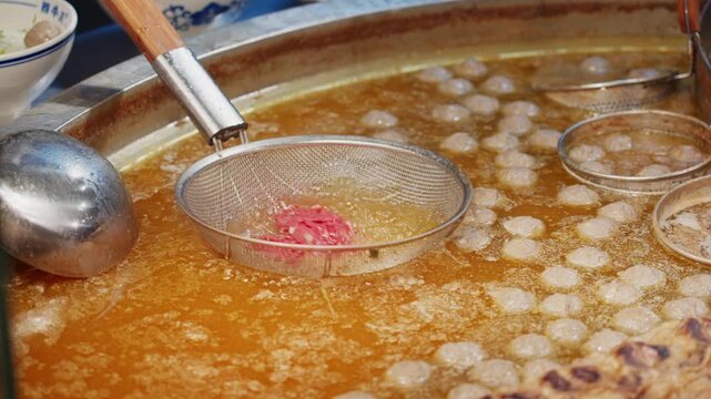 Close-up of Guizhou beef noodles boiling in the original broth with fresh beef
