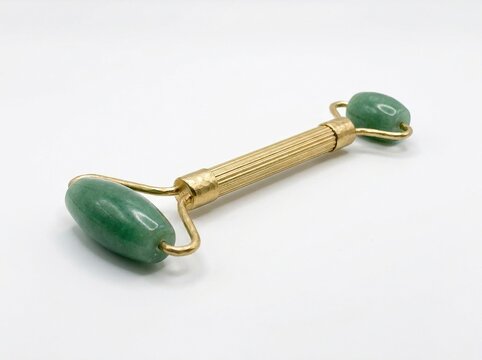 Green jade facial roller tool for skincare massage isolated on white background